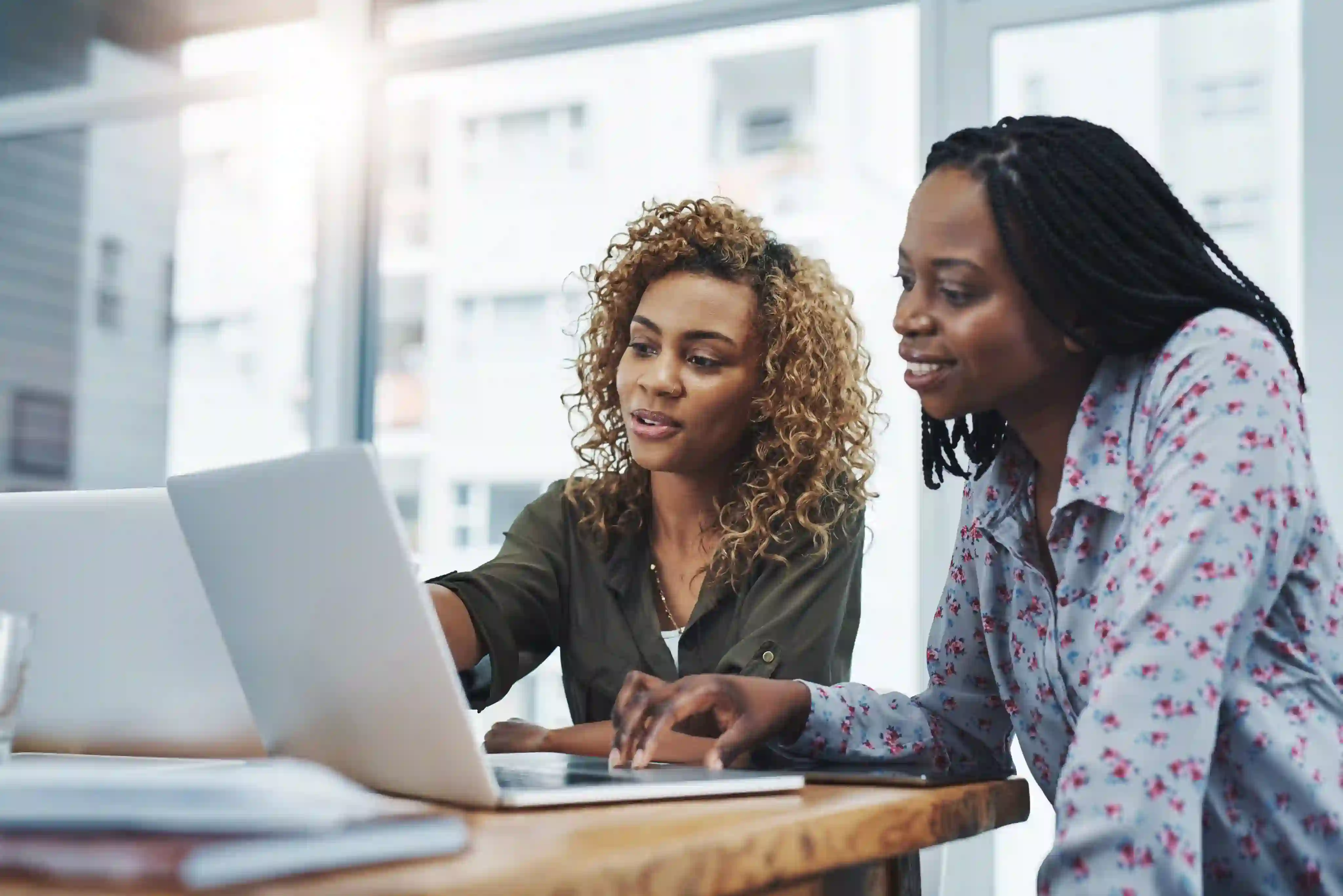Two women working together on a laptop